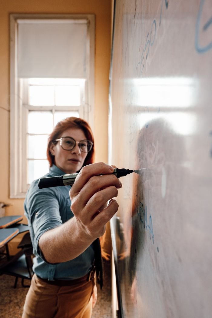 Crafting Captivating Headlines: Your awesome post title goes here A dedicated teacher in Buenos Aires explains concepts on the classroom whiteboard.