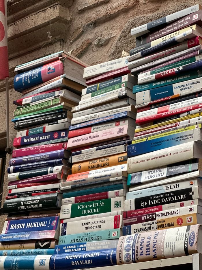 Services Stack of various books focused on legal, administrative, and law subjects in an indoor setting.